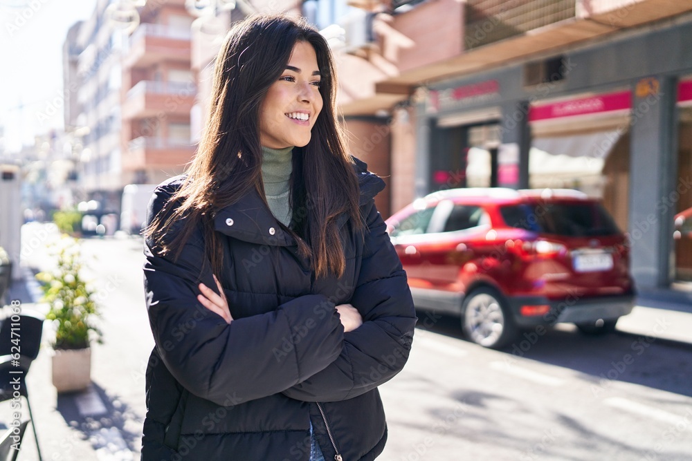 Fototapeta premium Young beautiful hispanic woman standing with arms crossed gesture at street