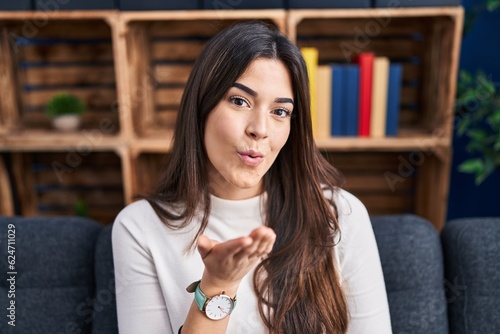 Wallpaper Mural Young beautiful hispanic woman sitting on sofa doing kiss gesture at home Torontodigital.ca