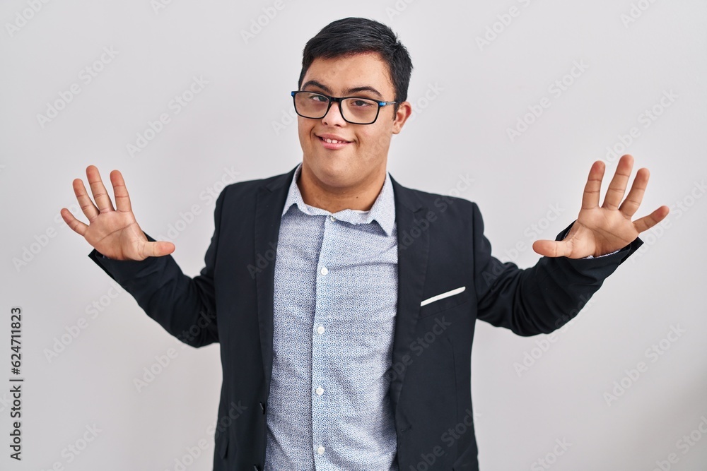 Young hispanic man with down syndrome wearing business style showing and pointing up with fingers number ten while smiling confident and happy. Young hispanic man with down syndrome wearing business style showing and pointing up with fingers number ten while smiling confident and happy.