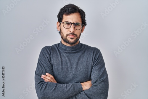 Принти на полотні Handsome latin man standing over isolated background skeptic and nervous, disapproving expression on face with crossed arms