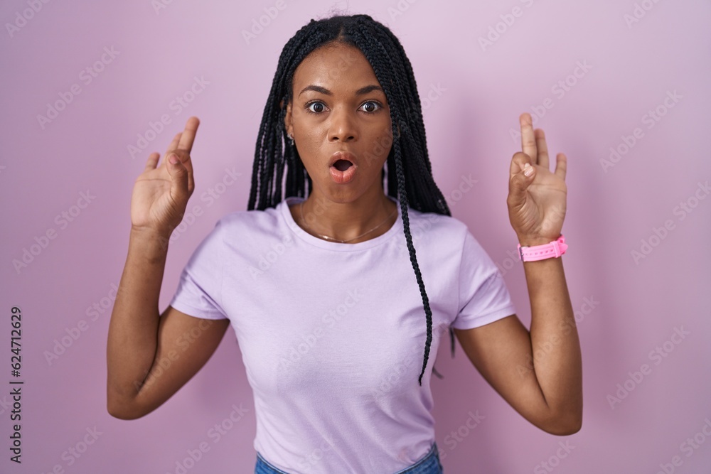 African american woman with braids standing over pink background looking surprised and shocked doing ok approval symbol with fingers. crazy expression African american woman with braids standing over pink background looking surprised and shocked doing ok approval symbol with fingers. crazy expression