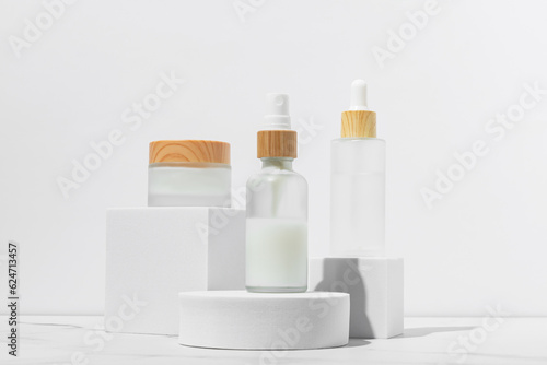 Cosmetics packaging. Set of different cosmetic jars and tubes of cream on white podiums. Blank packaging. Natural beauty spa product concept. Beauty.Mock-up