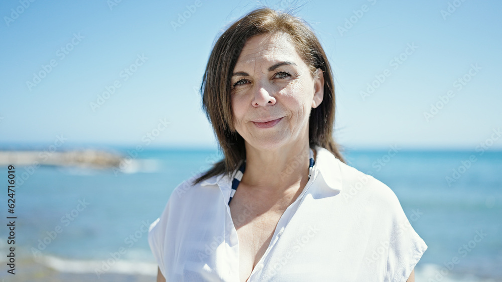 Middle age hispanic woman tourist smiling at the beach Middle age hispanic woman tourist smiling at the beach