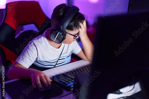 Adorable hispanic boy streamer stressed using computer at gaming room © Krakenimages.com