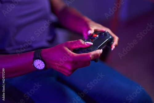 African american woman playing video game using joystick at gaming room