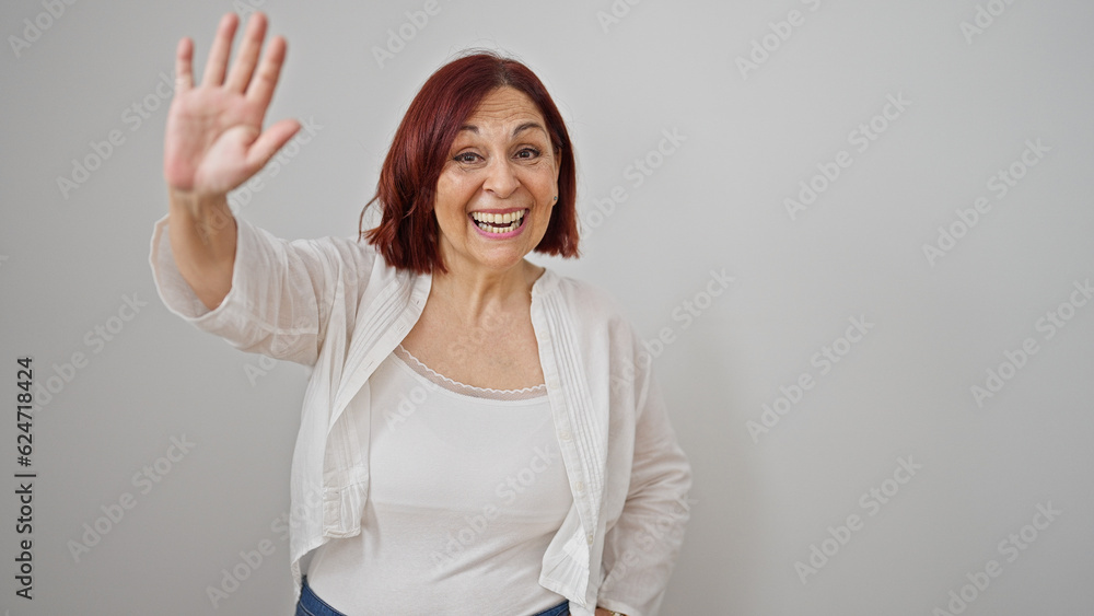 Middle age woman smiling confident saying hello with hand over isolated white background Middle age woman smiling confident saying hello with hand over isolated white background