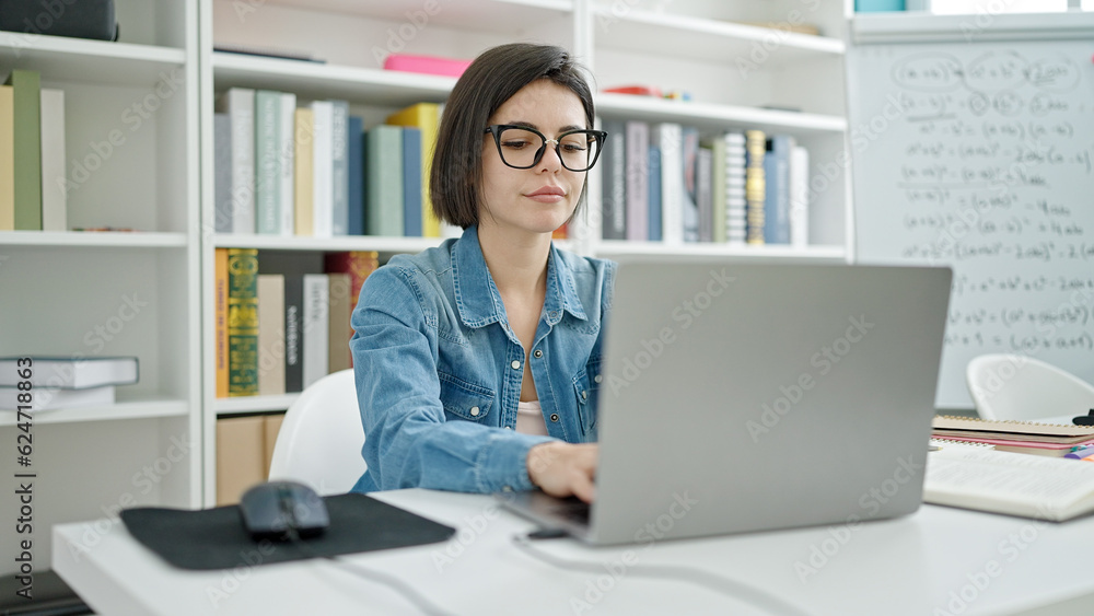 Young caucasian woman student using laptop studying at university classroom Young caucasian woman student using laptop studying at university classroom