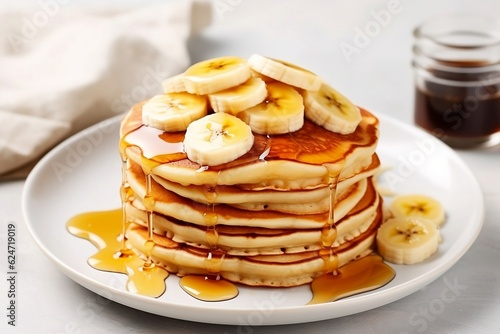 A mountain of pancakes with banana and honey