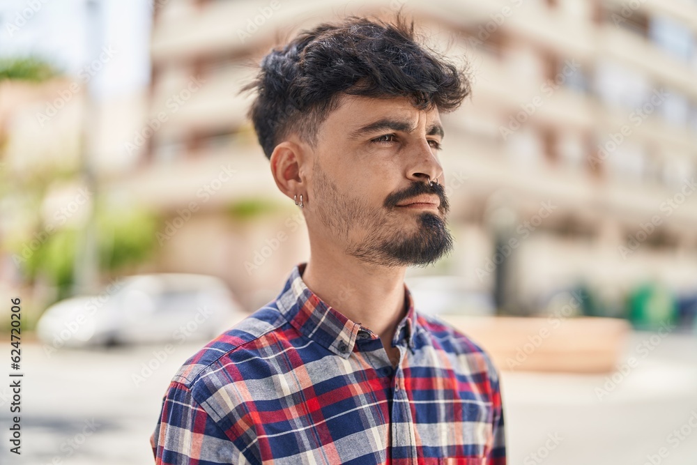 Young hispanic man looking to the side with relaxed expression at street Young hispanic man looking to the side with relaxed expression at street