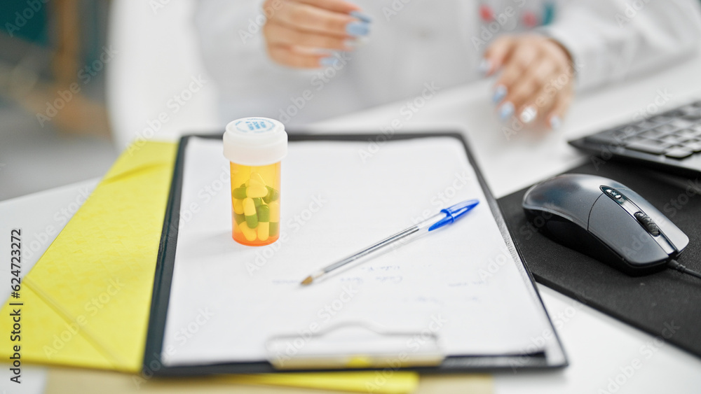 Young caucasian woman doctor sitting on table at clinic Young caucasian woman doctor sitting on table at clinic