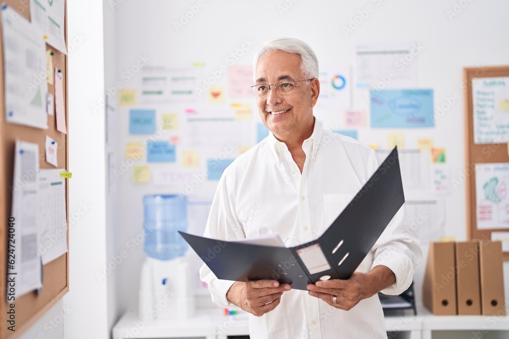 Middle age grey-haired man business worker reading document at office Middle age grey-haired man business worker reading document at office