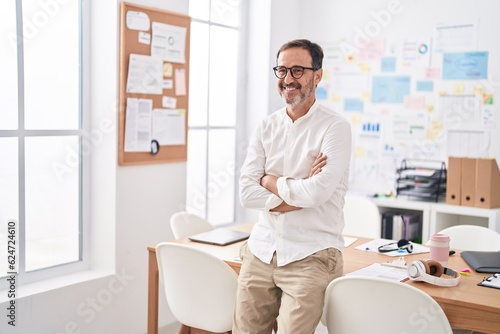 Middle age man business worker smiling confident standing with arms crossed gesture at office