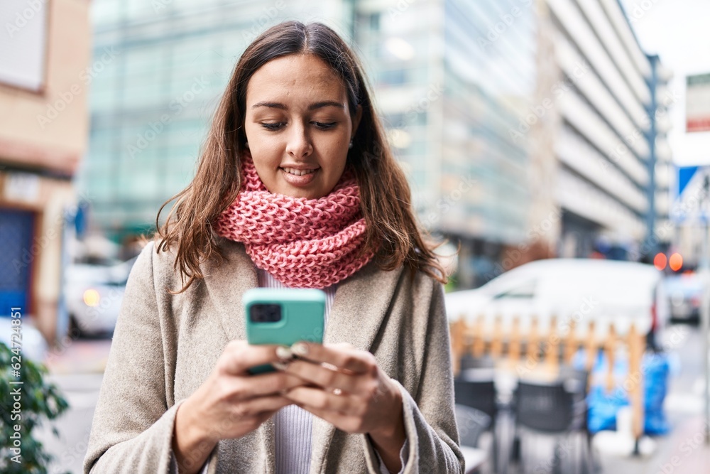 Young beautiful hispanic woman using smartphone wearing scarf at street Young beautiful hispanic woman using smartphone wearing scarf at street