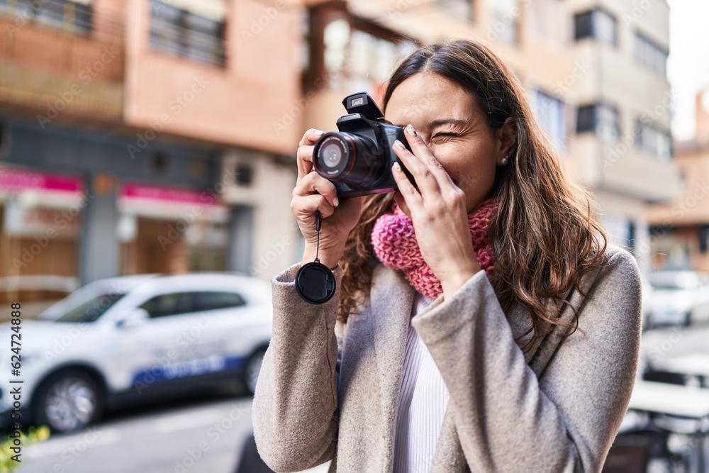 Young beautiful hispanic woman wearing scarf using professional camera at street