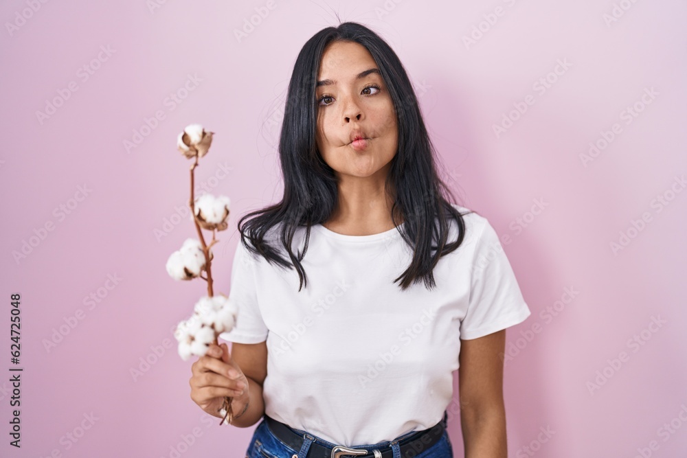 Brunette woman standing over pink background making fish face with lips, crazy and comical gesture. funny expression. Brunette woman standing over pink background making fish face with lips, crazy and comical gesture. funny expression.