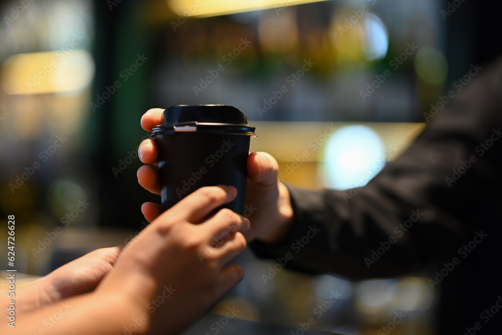 Cropped shot of male barista serving coffee to customer in cafe. Start up, small business owner, food and drink concept Cropped shot of male barista serving coffee to customer in cafe. Start up, small business owner, food and drink concept