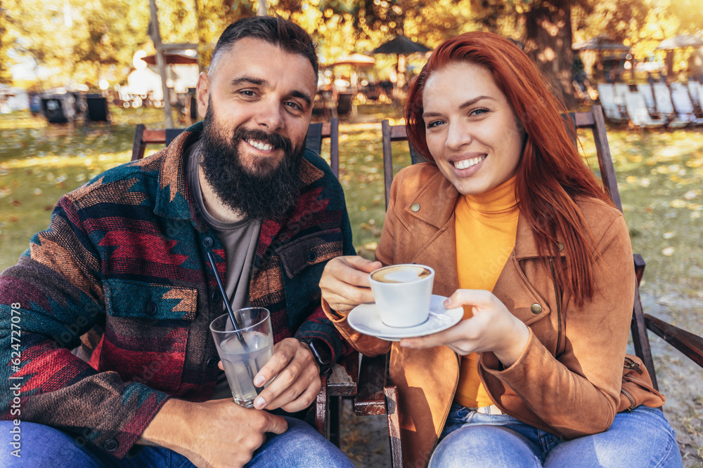 Beautiful loving couple sitting in a cafe enjoying in coffee and conversation. Beautiful loving couple sitting in a cafe enjoying in coffee and conversation.