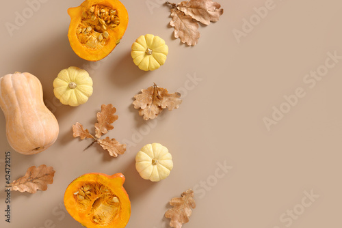 Autumn composition of white pumpkins and falled oak leaves on beige background. Seasonal fall flat lay. Top view. Thanksgiving Day. Copy space.