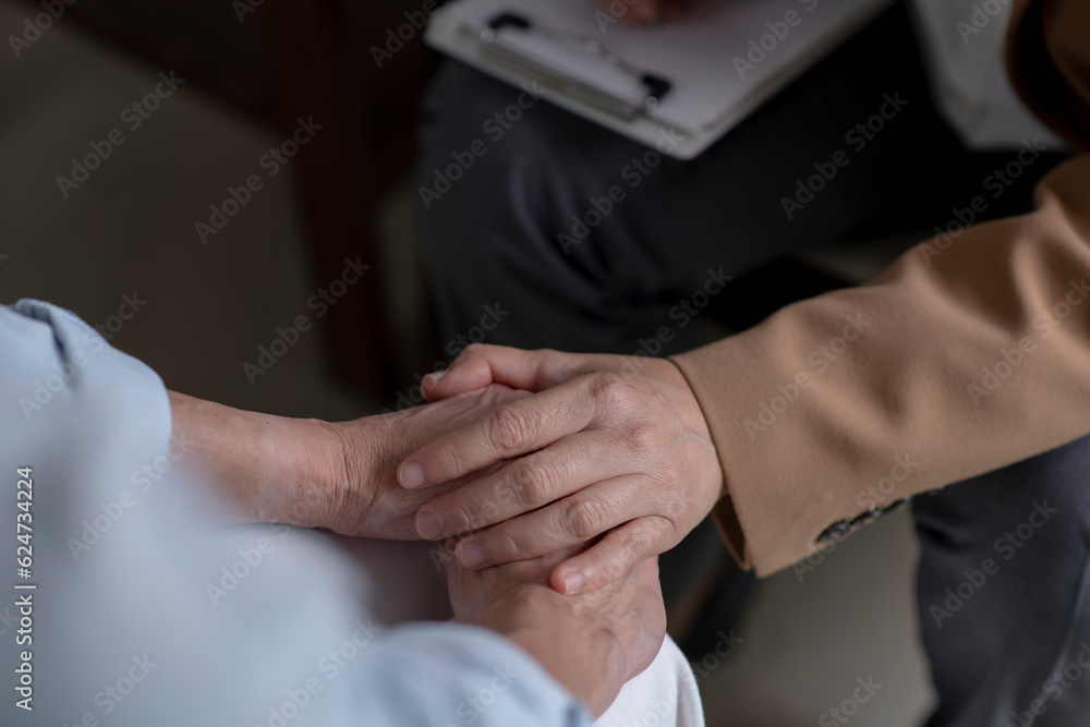 Female therapist, psychologist holding patient’s hands to give support and assurance