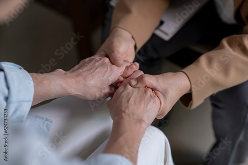 Female therapist, psychologist holding patient’s hands to give support and assurance