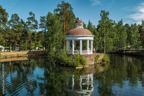 The gazebo stands on the bank of a pond.