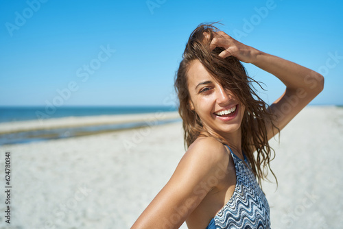 Portrait of smiling pretty woman in the beach. Warm sun, smooth skin, carefree getaway on seaside vacation.