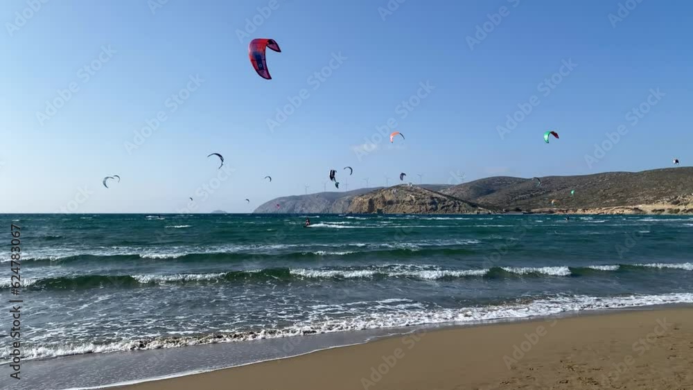 Surfers in Prasonisi Beach in Rhodes island, Greece. Kiteboarder kitesurfer athlete performing kitesurfing kiteboarding tricks. Prasonisi Beach is popular location for surfing. Greece Surfers in Prasonisi Beach in Rhodes island, Greece. Kiteboarder kitesurfer athlete performing kitesurfing kiteboarding tricks. Prasonisi Beach is popular location for surfing. Greece