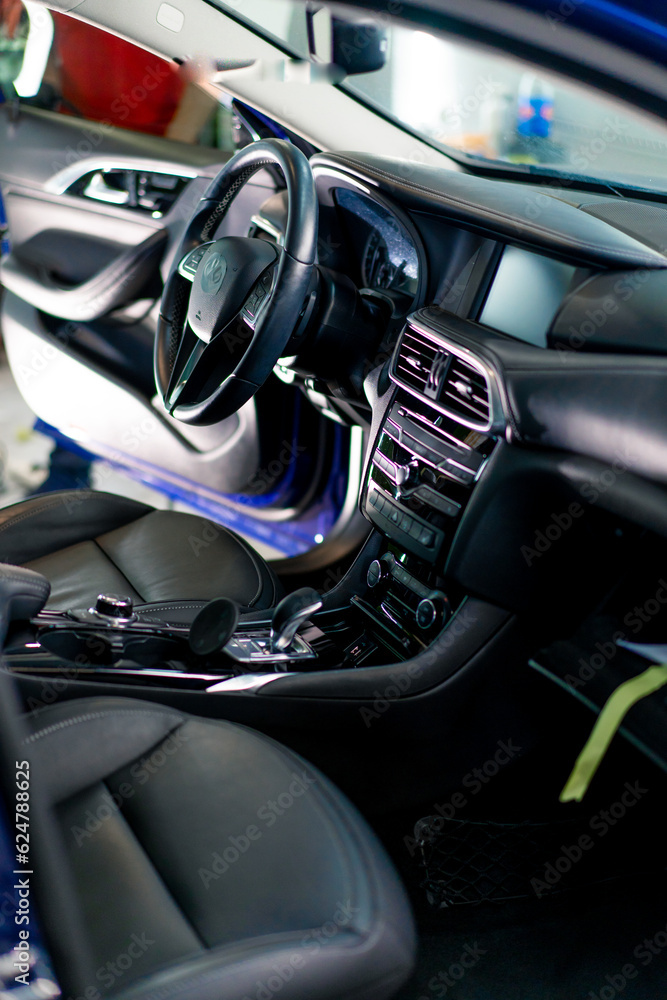 Close-up of the steering wheel of a luxury car with a black interior after dry cleaning and washing detailing