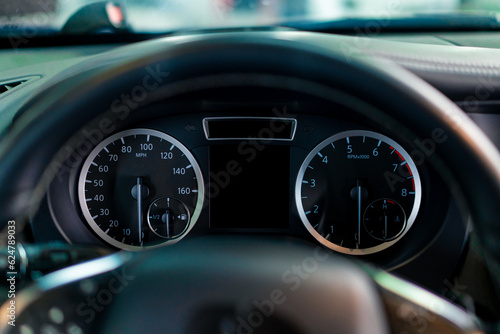 Close-up of the odometer and dashboard of a luxury car with a black interior after detailing and washing at a car service