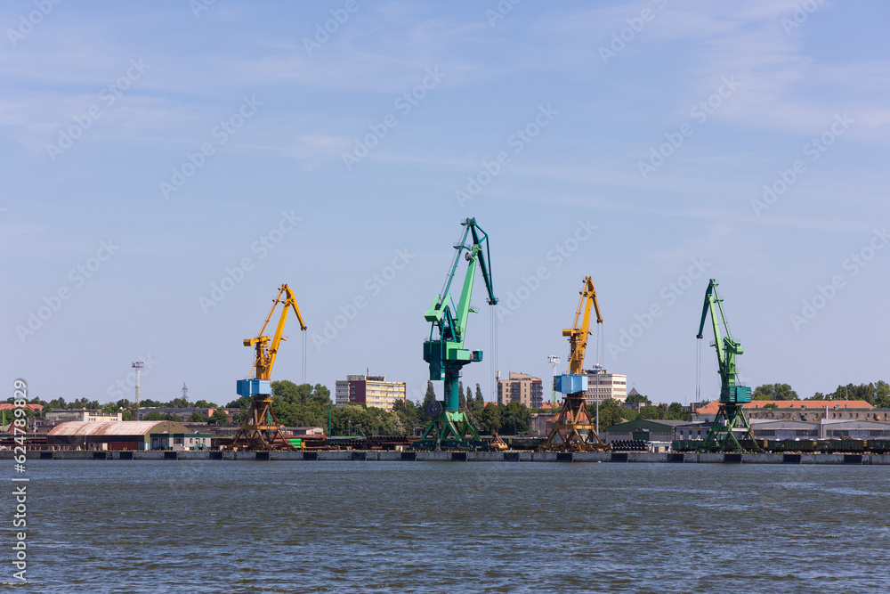 Many harbor cranes on the jetty. Bulk material handling. Photo taken from on a sunny day.