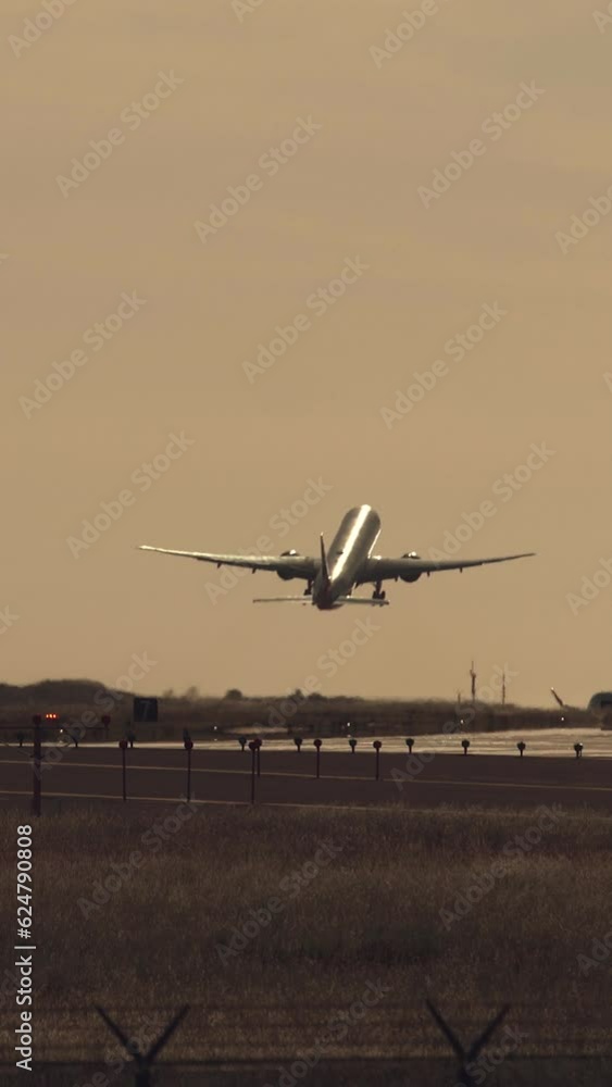Large passenger airplane taking off against beautiful sunset. Jet plane taking off and climbing into the sunset. Aerial vertical background, vertical video background, vertical video. Large passenger airplane taking off against beautiful sunset. Jet plane taking off and climbing into the sunset. Aerial vertical background, vertical video background, vertical video.