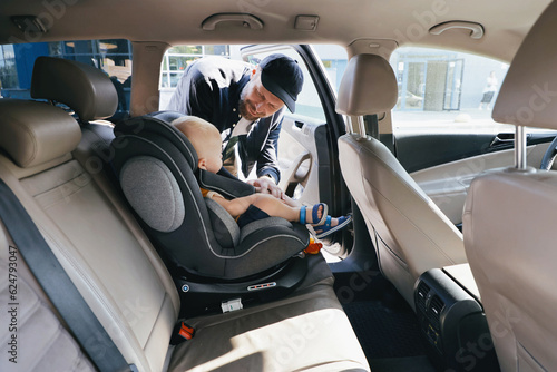 The man fastened in the car in the back seat of the baby in the child car seat