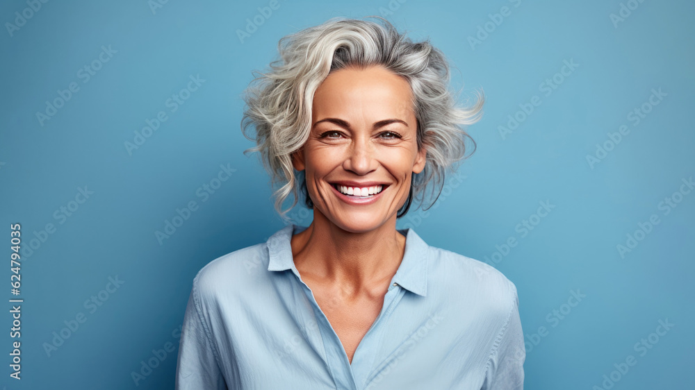 Smiling attractive woman 50s years old look to the camera, isolated on plain blue background studio portrait. People lifestyle concept. AI Generated. Smiling attractive woman 50s years old look to the camera, isolated on plain blue background studio portrait. People lifestyle concept. AI Generated.