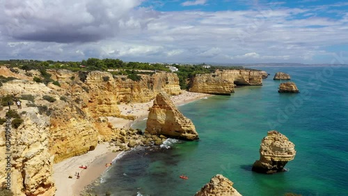 Praia da Marinha, beautiful beach Marinha in Algarve, Portugal. Navy Beach (Praia da Marinha) with flying seagulls over the beach, located on the Atlantic coast in Lagoa Municipality, Algarve.