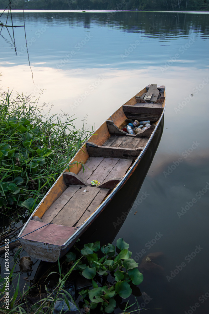Fishing wooden boat on the river bank
