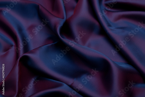 Texture of purple fabric curves wave lines background. Beautiful lilac soft silk fabric. Texture, background, pattern