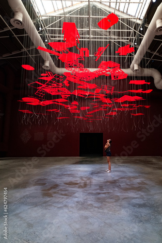 Girl looking at the work craft hanging in the empty hall during Venice Biennale 2023