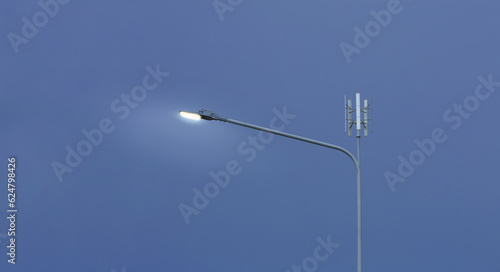 Fototapeta Naklejka Na Ścianę i Meble -  Small wind turbine on street light pole with blue sky background, Lamp post with solar and wind turbine alternative energy for better world concept