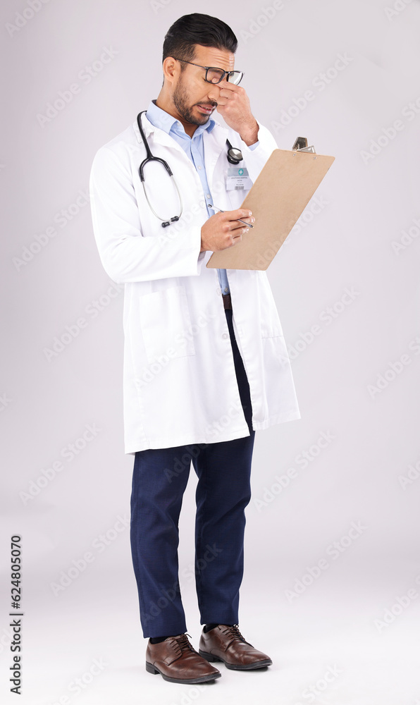 Tired man, doctor and headache with clipboard in burnout, stress or overworked against a grey studio background. Medical or healthcare male person with head pain, mental health or bad clinic results Tired man, doctor and headache with clipboard in burnout, stress or overworked against a grey studio background. Medical or healthcare male person with head pain, mental health or bad clinic results