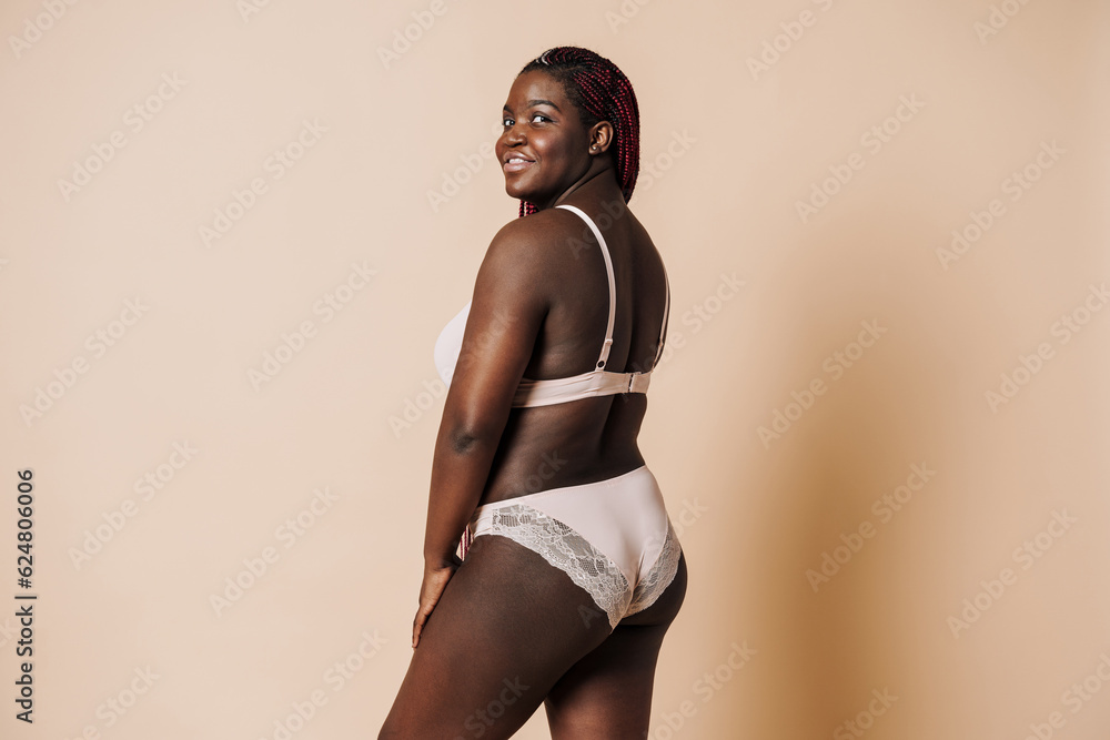 Beautiful smiling african woman in lingerie standing with her back Beautiful smiling african woman in lingerie standing with her back