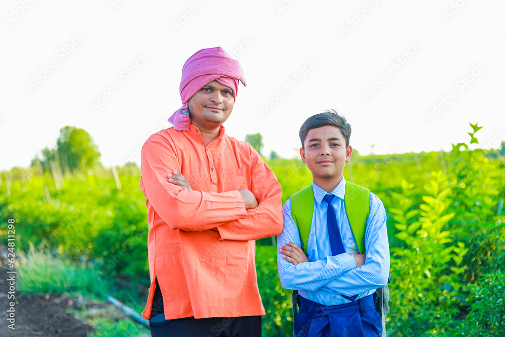 Cute indian farmer child in school uniform with his father at agriculture field Cute indian farmer child in school uniform with his father at agriculture field