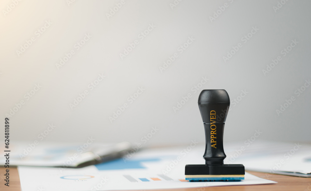 Close-up of Seal or stamp is placed on the document with approved stamp on text approved document at desk, validates and manages business documents and agreements, Contract form paper. Approval stamp. Close-up of Seal or stamp is placed on the document with approved stamp on text approved document at desk, validates and manages business documents and agreements, Contract form paper. Approval stamp.