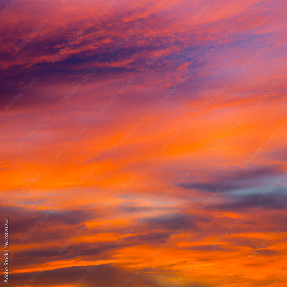 Vibrant orange red colours of sunset sky with clouds. Dramatic sky, light majestic sunset