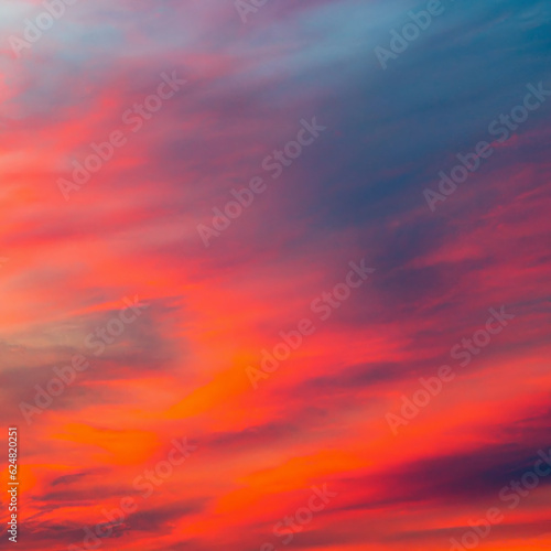 Obraz na płótnie Vibrant orange red colours of sunset sky with clouds. Dramatic sky, light majestic sunset w salonie