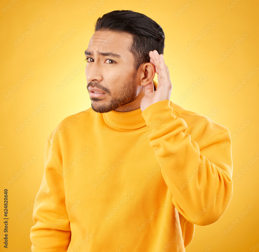 Φωτογραφία Whisper, gossip and asian man with hand on ear in studio for speak up body language on yellow background