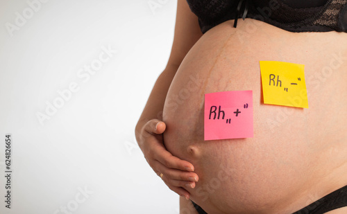 Fotografía Stickers on the belly of a pregnant girl with inscriptions negative and positive Rh factor