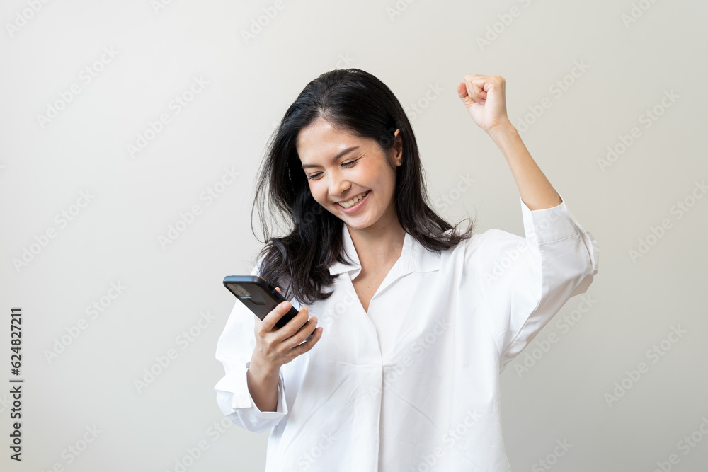 Happy Asian woman holding a smartphone and winning the prize. Happy Asian woman holding a smartphone and winning the prize.