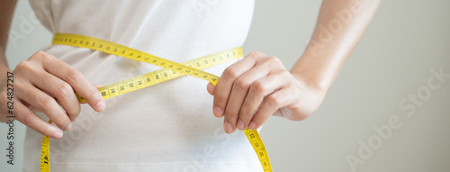 Close-up woman measuring her shape after weight loss session.