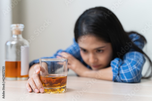 depression and anxiety woman drinking whisky alone.