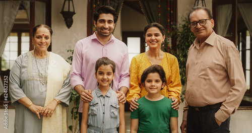Portrait of Happy Indian Family Posing Together in Beautifully Authentic Mumbai House. Gorgeous Parents, Grandparents, and Cute Two Kids Looking at the Camera, Happily Taking a Family Photo